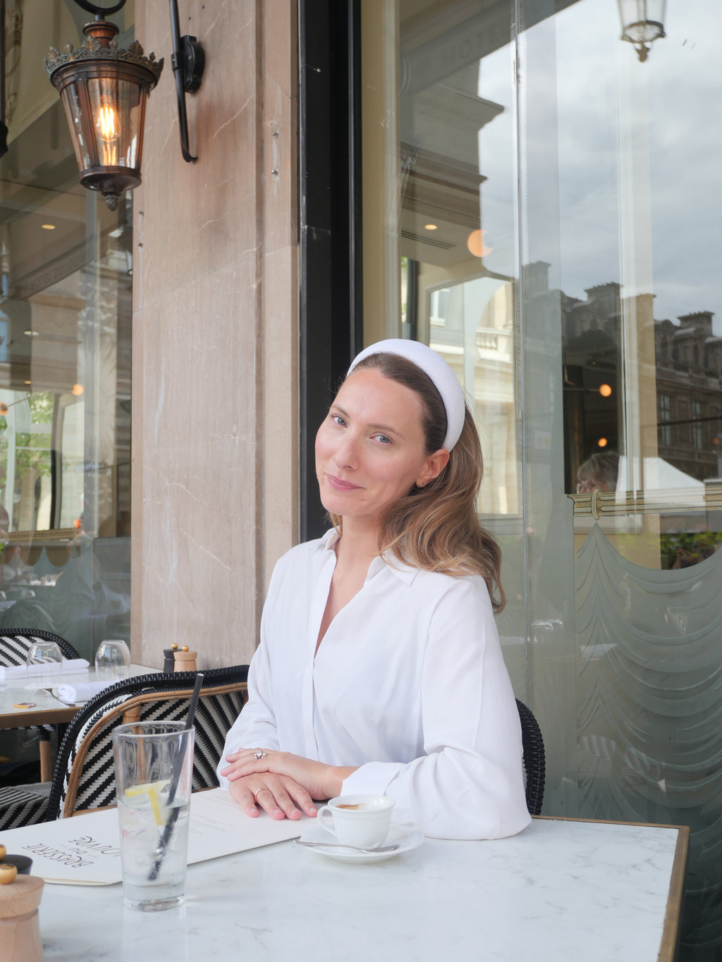 Serre-tête en sinamay blanc Raphia Paris porté dans un look élégant