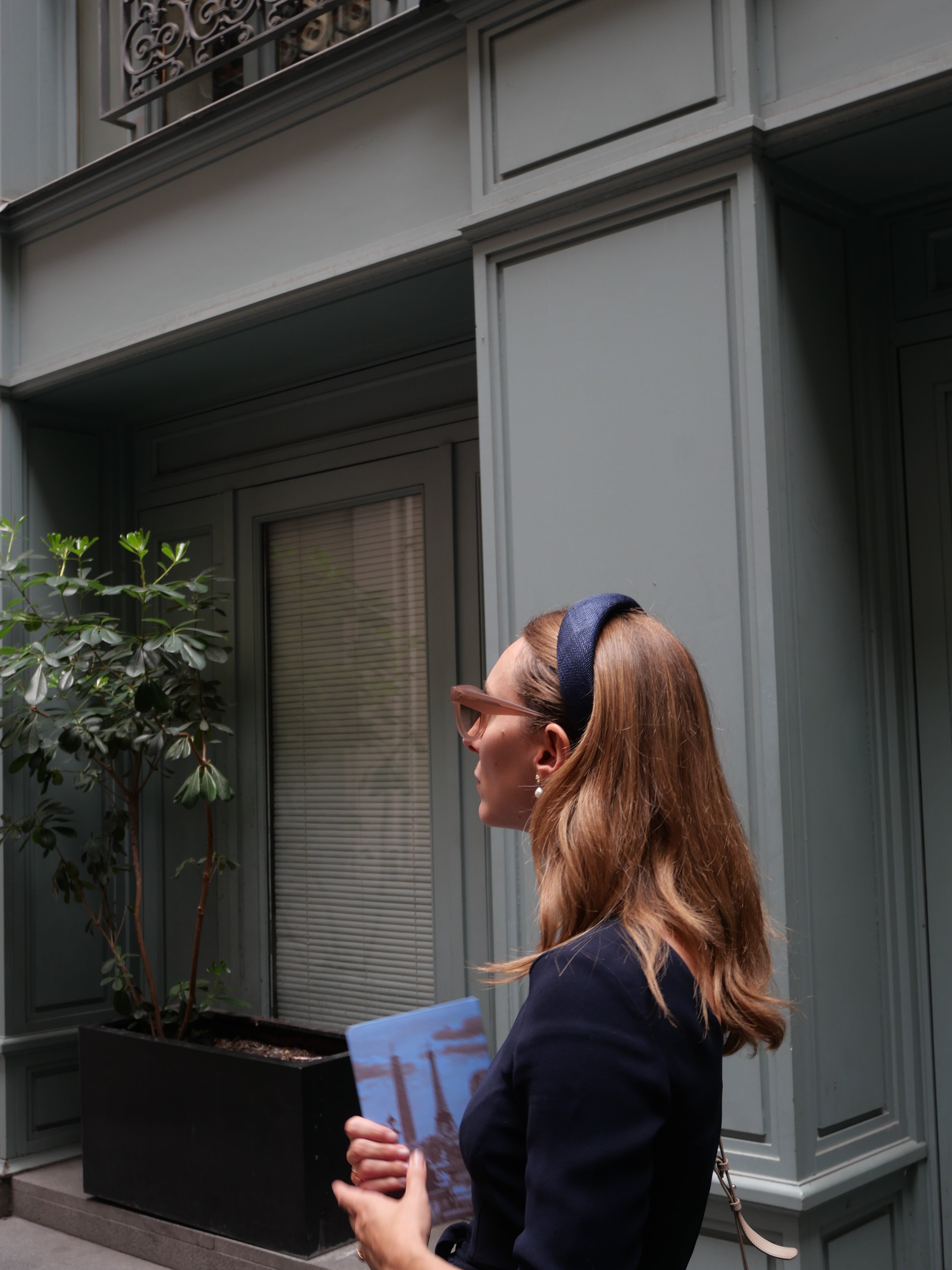 Femme portant un serre-tête Raphia Paris dans un look chic