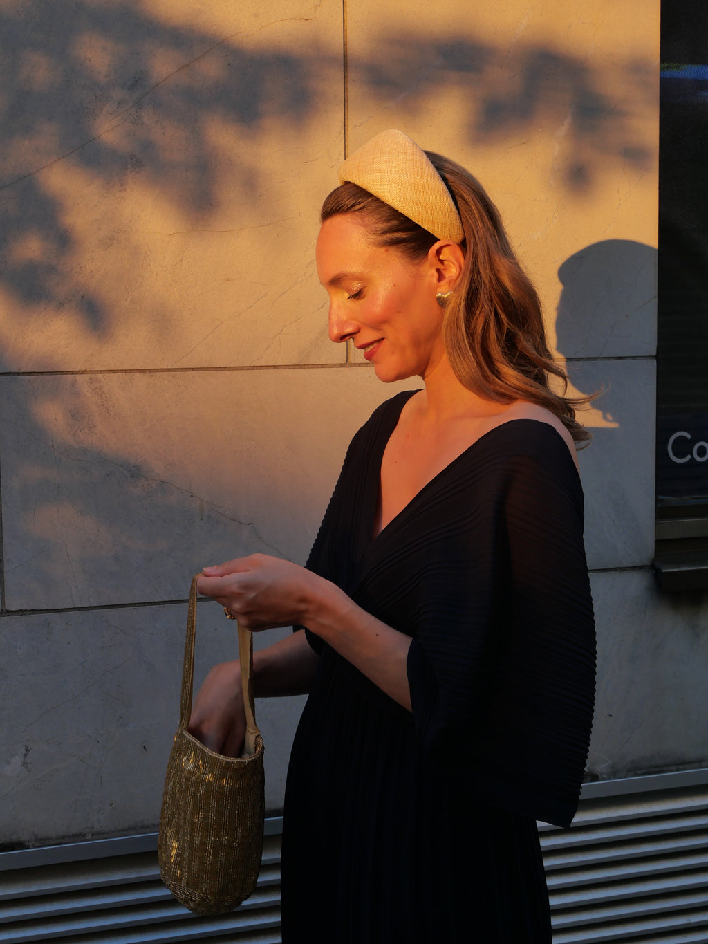 Femme portant un serre-tête Raphia Paris avec un look d’invitée de mariage