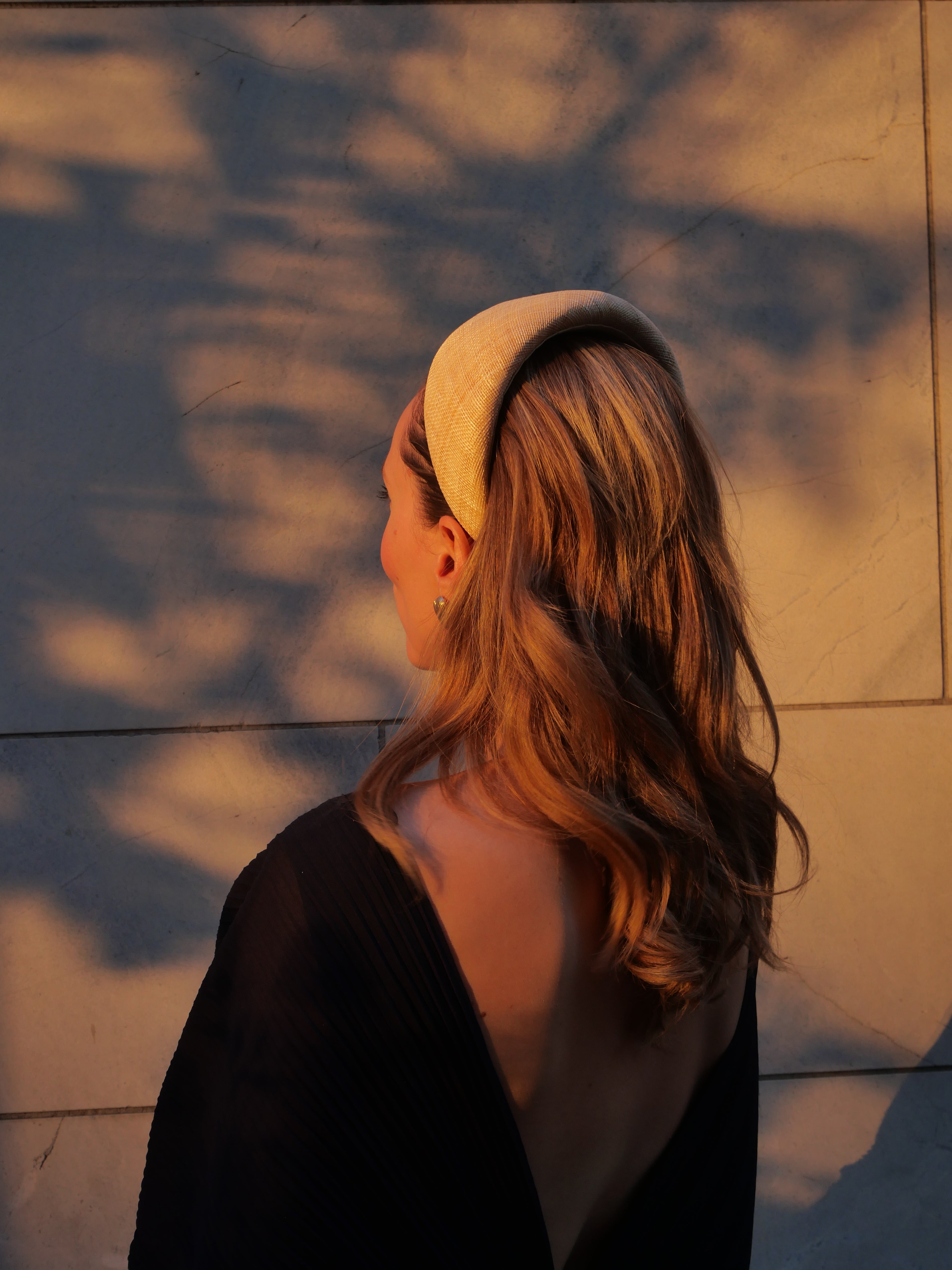 Femme portant un serre-tête Raphia Paris avec un look d’invitée de mariage