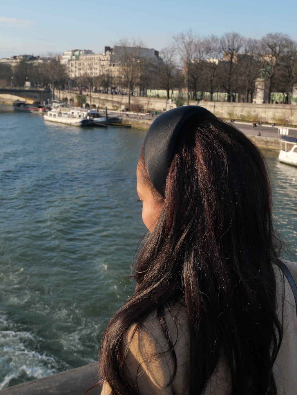 Détail d’un serre-tête Raphia Paris porté dans les cheveux